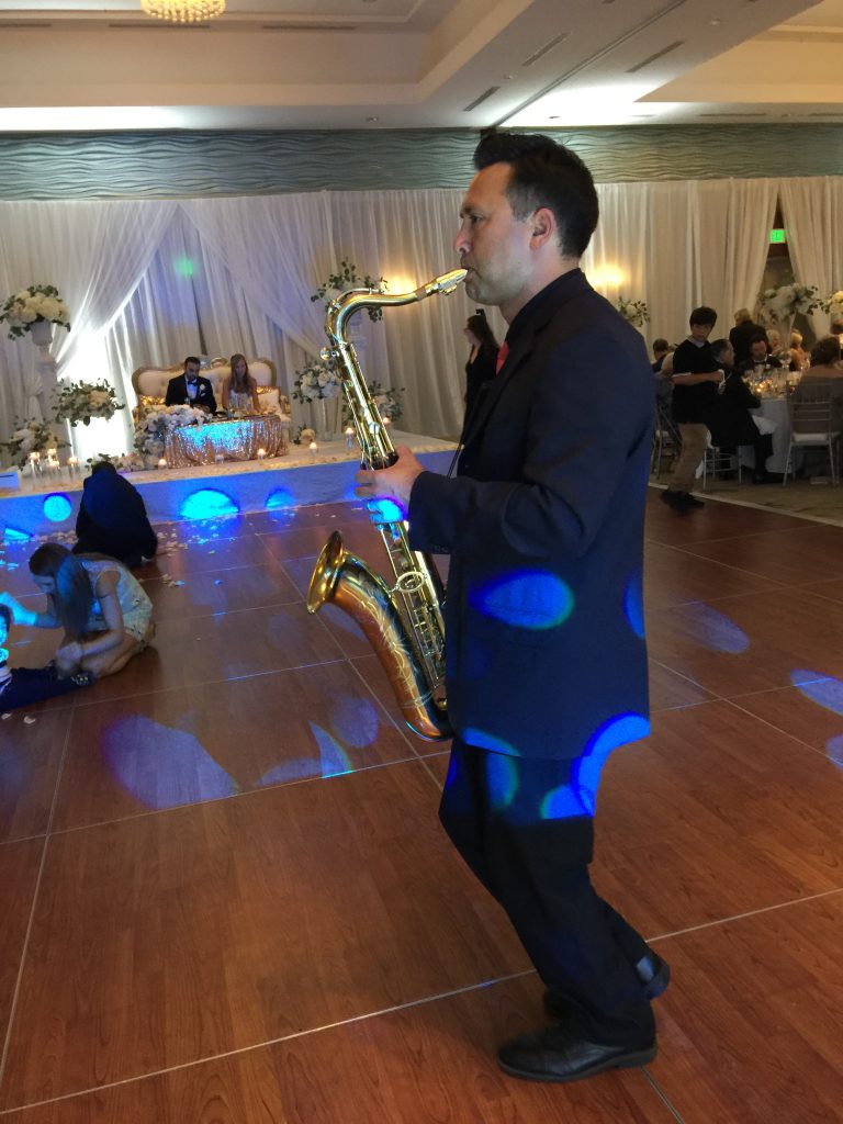 Saxophone player in front of bride and groom